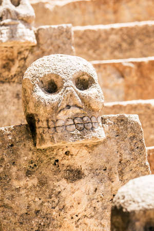 Closeup of scary Mexican stone skulls with stairs in the backgroundの写真素材