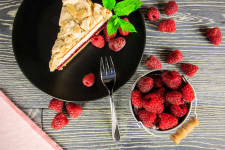 Raspberry cake with meringue top arranged on a wooden tableの写真素材
