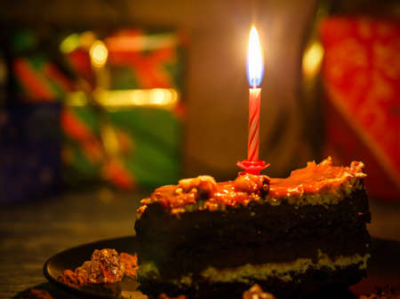 Birthday cake with presents in the backgroundの写真素材