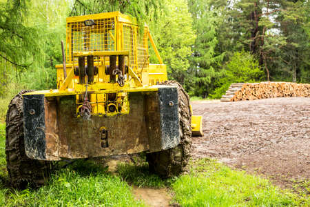 Old bulldozer and wooden bales in a forestの写真素材