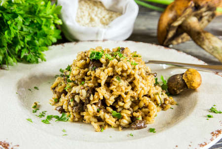 Italian risotto with mushrooms arranged on a wooden tableの写真素材