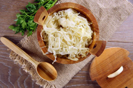 Sauerkraut in a wooden barrel on brown tableの写真素材