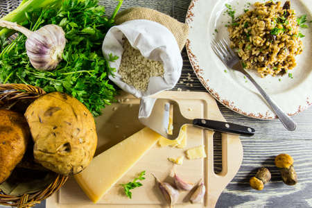 Ingredients of Italian risotto with mushrooms arranged on a wooden tableの写真素材