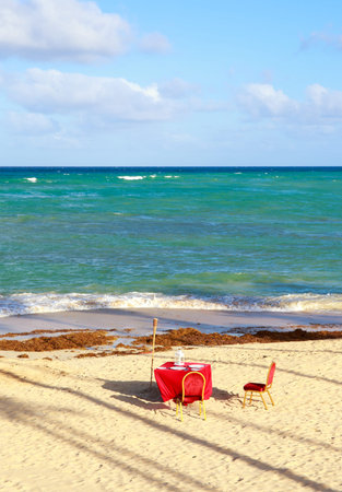 Dinner table on caribbean sandy beachの写真素材