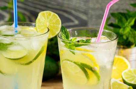 Refreshing lemonade drink and ripe fruits against wooden backgroundの写真素材