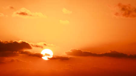 Gold sky, sun and small clouds. Early morning horizon.の写真素材