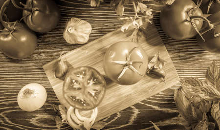 Fresh tomato and vegetables arranged on a wooden tableの写真素材