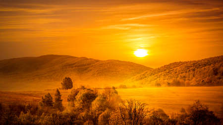 Golden sunrise over european mountains and forestの写真素材