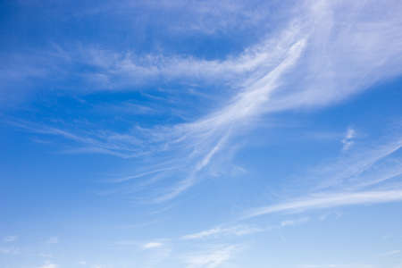 Blue sky and white fluffy clouds backgroundの写真素材
