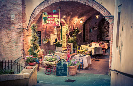 MONTEPULCIANO, ITALY - JUNE 25, 2015: small pizza restaurant with beautiful flowers decoration in antique Montepulciano city, Italyのeditorial素材