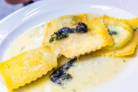 Italian ravioli in a sauce with spinach and parmesan cheeseの写真素材