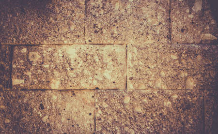Closeup of golden yellow abstract brick wall backgroundの写真素材