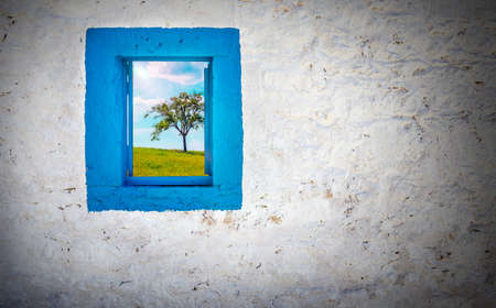Blue window on white wall with view on rural landscapeの写真素材
