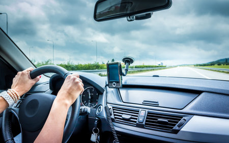 Woman driving a car and using a navigation device