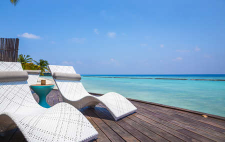 Deckchair and beautiful turquoise Indian ocean in Maldivesの写真素材
