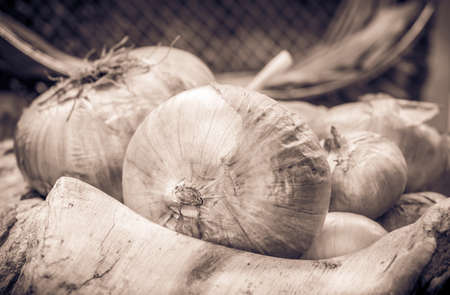 Sepia tone rustic still life, onions and wooden kitchenwareの写真素材