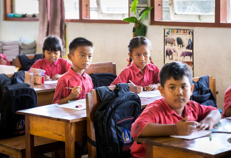 BALI, INDONESIA - APRIL 25, 2018: Young happy pupils wearing balinese school outfits studying at...