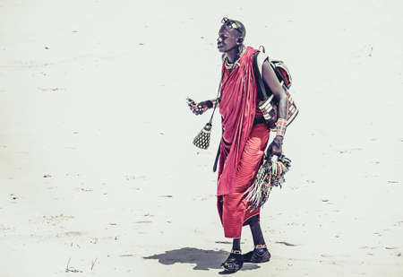 DIANI BEACH, KENYA - OCTOBER 14, 2018: Unindentified African man wearing traditional Masai clothes on Diani beach, Kenyaのeditorial素材