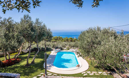 Private swimming pool with turquoise water and beautiful gardenの写真素材