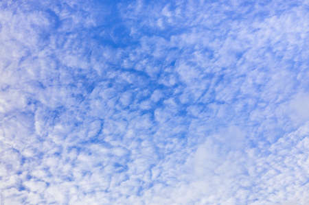 Blue sky and white fluffy clouds backgroundの写真素材