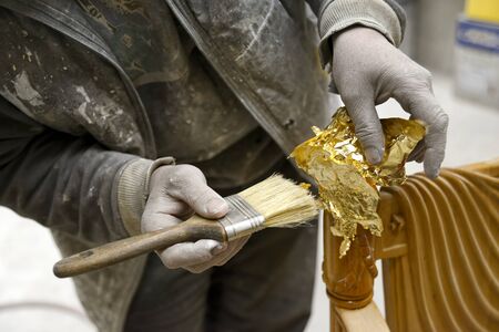 Carpenter Applying Golden Leaf To A Furnitureの写真素材