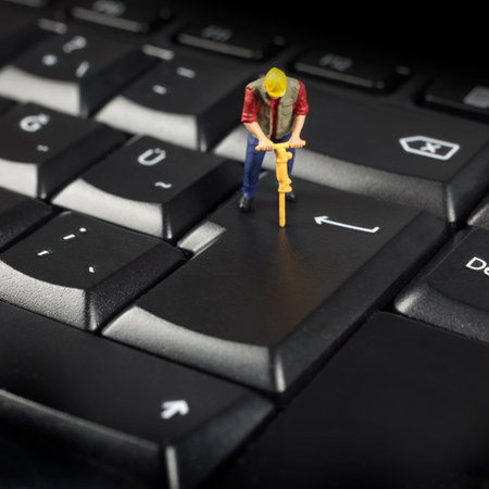 Miniature Worker On Top Of Black Computer Keyboardの写真素材