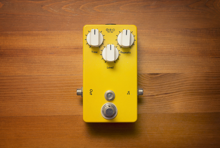 Yellow Guitar Pedal On Wooden Surfaceの写真素材