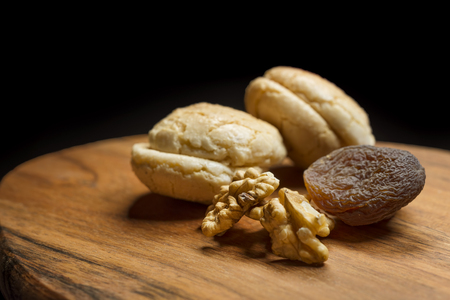 Macaroons, Crushed Walnuts And Dried Apricots On A Wooden Surfaceの写真素材