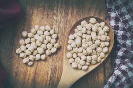 Wooden Scoop Full Of Chickpeas On A Wooden Surfaceの写真素材