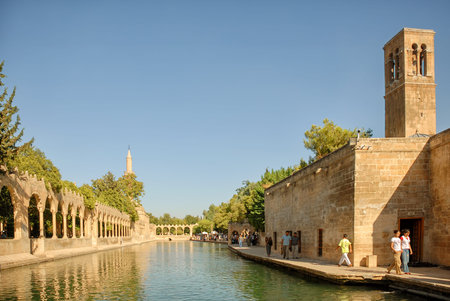 Tourists visiting Holy lake with fishes in Golbasi Park and Halil Rahman Mosque, famous landmark of...