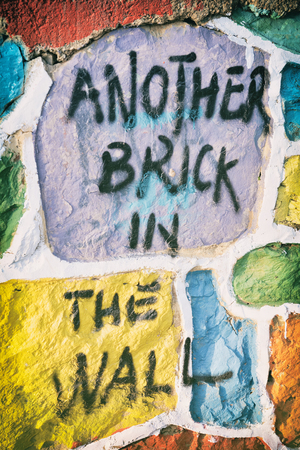 "Another Brick In The Wall" famous song of Pink Floyd sprayed on colorful wallの写真素材