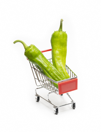 Green Sweet Peppers Loaded On A Miniature Shopping Cart, Isolated On White Backgroundの写真素材