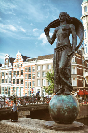 AMSTERDAM, NETHERLANDS, JULY 12, 2012: Statue Of Lady Fortune (Statue Vrouwe Fortuna) in front of traditional Dutch houses, statue is made by the sculptor Hildo Krop.のeditorial素材