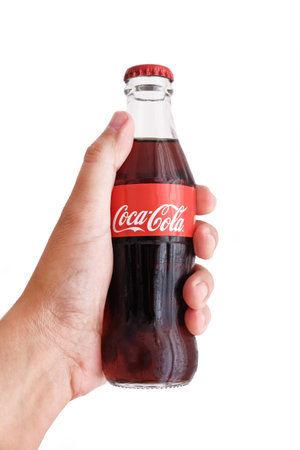 Istanbul, Turkey - September, 24, 2021: Male hand holding a Coca Cola bottle, a carbonated soft drink manufactured by The Coca-Cola Company.のeditorial素材