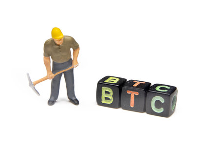 Plastic Miniature Worker With Pickaxe Looking At Bitcoin Cubes, Isolated On White Backgroundの写真素材