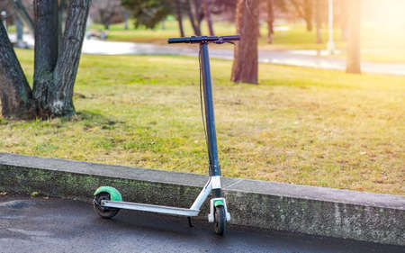 Electric Scooter Used and Paid for Through a Mobile App, Parked in a City Park, Eco Friendly Means of Transportation with Zero Emissionの写真素材
