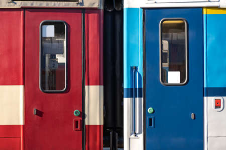 Closed Side Door of a Passenger Train Waiting on the Train Platform, Red and Blue Passage Carの写真素材