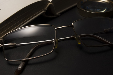 Ophthalmologist concept with book, eyeglasses and magnifying glass. High resolution image.の写真素材