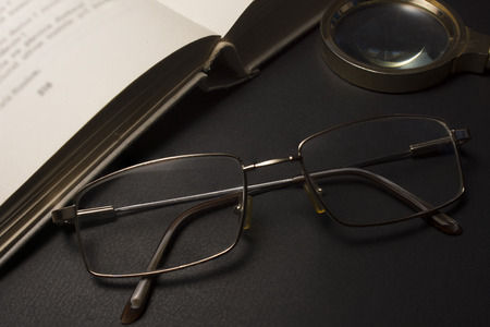 Ophthalmologist concept with book, eyeglasses and magnifying glass. High resolution image.の写真素材