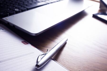High resolution image, showing a desk working space, with laptop, agenda, pen, phone.の写真素材