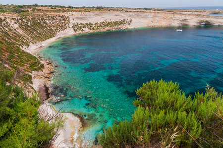 Incredible colors of view on colorful rocks on coastline in Malta. Juicy blue and green sea, blue sky. Beautiful landscapce. Hiking way on cliffs. Unforgettable scenery.の写真素材