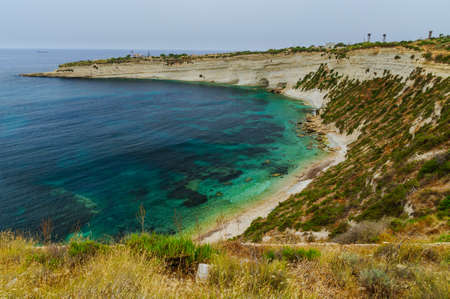 Incredible colors of view on colorful rocks on coastline in Malta. Juicy blue and green sea, blue sky. Beautiful landscapce. Hiking way on cliffs. Unforgettable scenery.の写真素材
