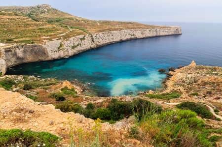 Incredible colors of view on colorful rocks on coastline in Malta. Juicy blue and green sea, blue sky. Beautiful landscapce. Hiking way on cliffs. Unforgettable scenery.の写真素材
