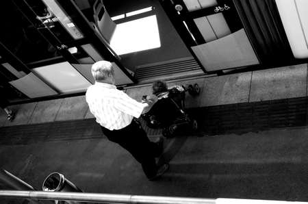 Grandfather and grandson entering into a trainの写真素材