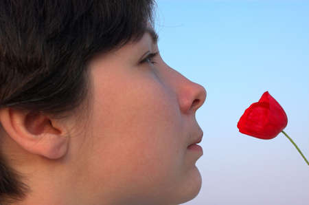 beautiful girl watching stare on the red poppyの写真素材