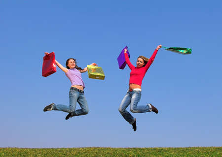 Two young women with color packets on green grassの写真素材