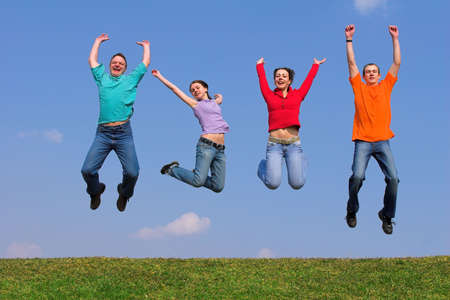 Four young people with color packets on green grasの写真素材