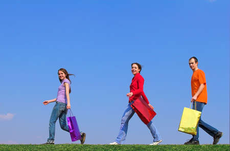 three young people with color packets on  green grass