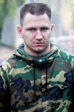 Strong man  in camouflage in the forestの写真素材