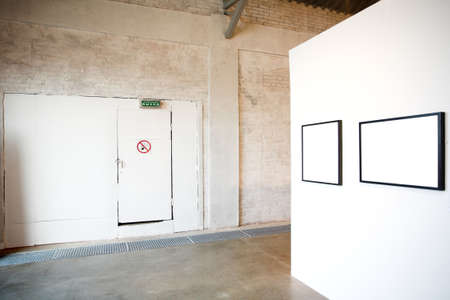 Two empty frames on white wall in museumの写真素材